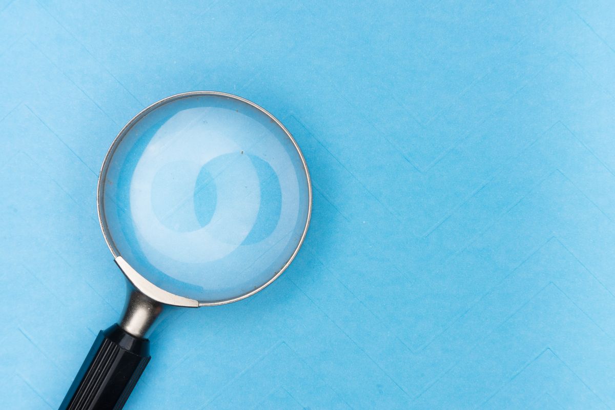 Lupa sobre fundo azul, simbolizando busca