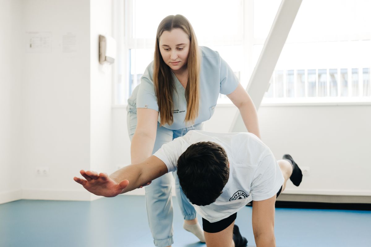 Fisioterapeuta acompanhando paciente em sessão de reabilitação